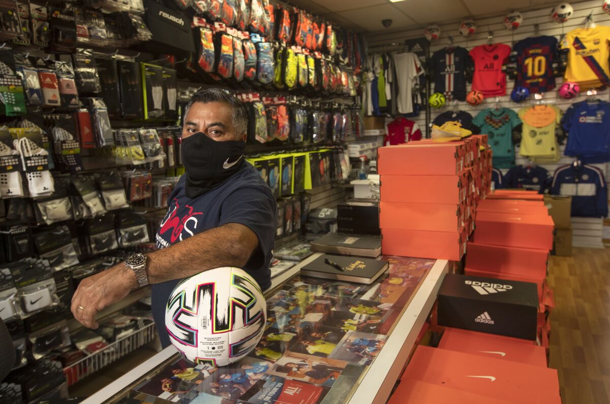 Carlos Marroquin stands in Planet Soccer, his store in Newhall.
