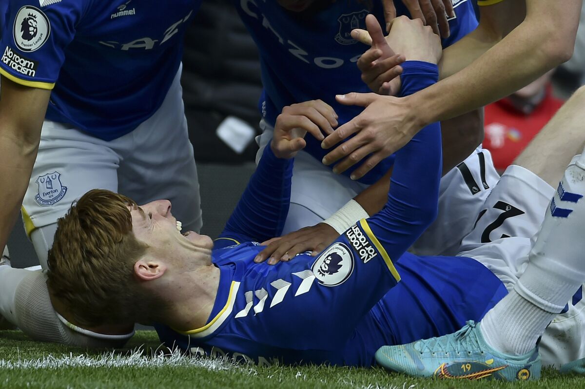 Everton's Anthony Gordon, on the ground, celebrates after scoring the opening goal during the Premier League soccer match between Everton and Manchester United at Goodison Park, in Liverpool, England, Saturday, April 9, 2022. (AP Photo/Rui Vieira)