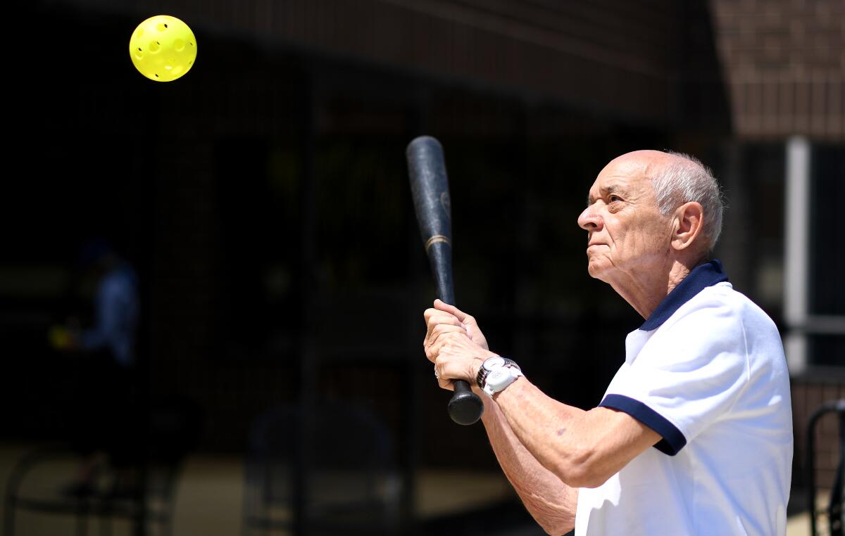 Richard Machinski takes a swing at a wiffle ball during a rooftop game.