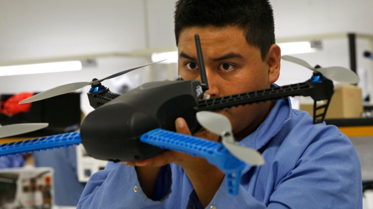 A drone is inspected at a manufacturing plant in Tijuana. (Don Bartletti / Los Angeles Times)
