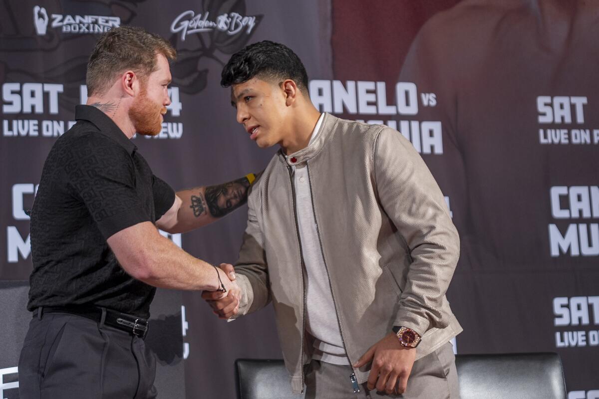 Canelo ?lvarez, left, shakes hands with Jaime Munguía during a news conference in Beverly Hills in March.