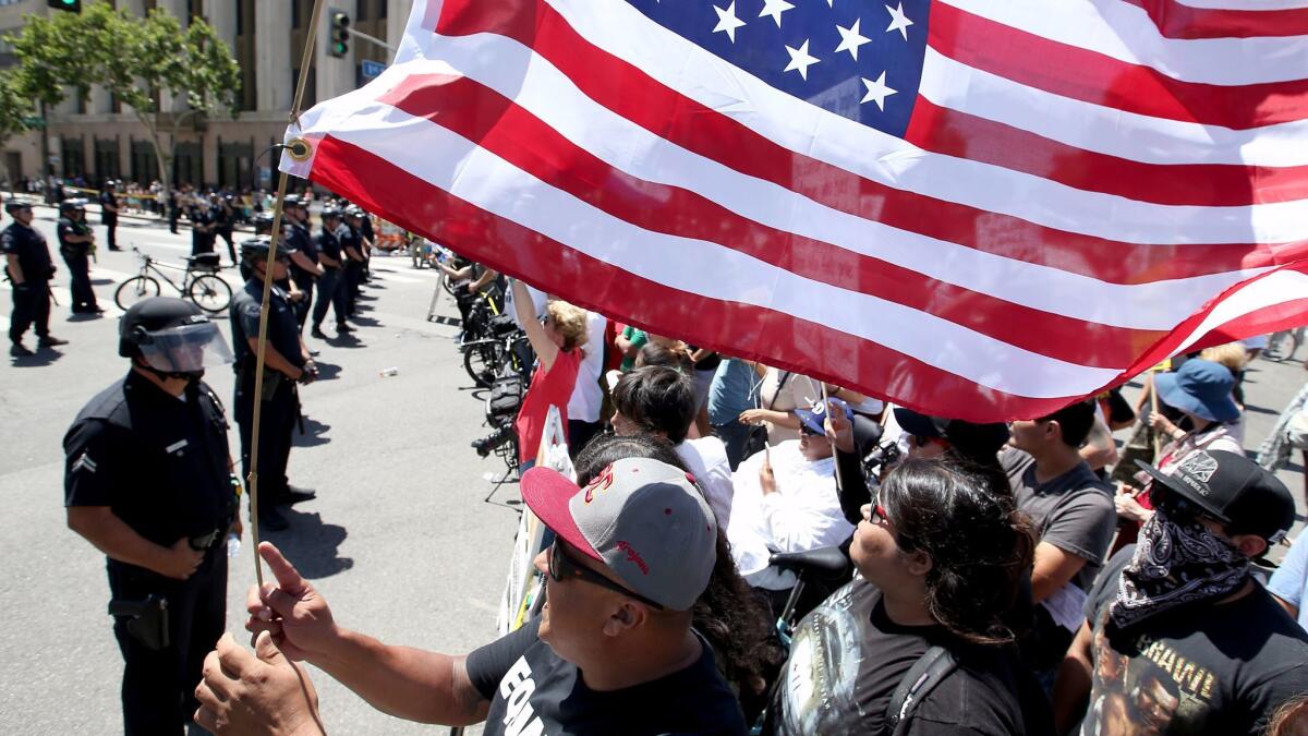 Anti-Trump protesters yell across the street at supporters of the president as separate May Day marches and rallies converge at 1st and Spring streets in downtown Los Angeles. (Luis Sinco / Los Angeles Times)