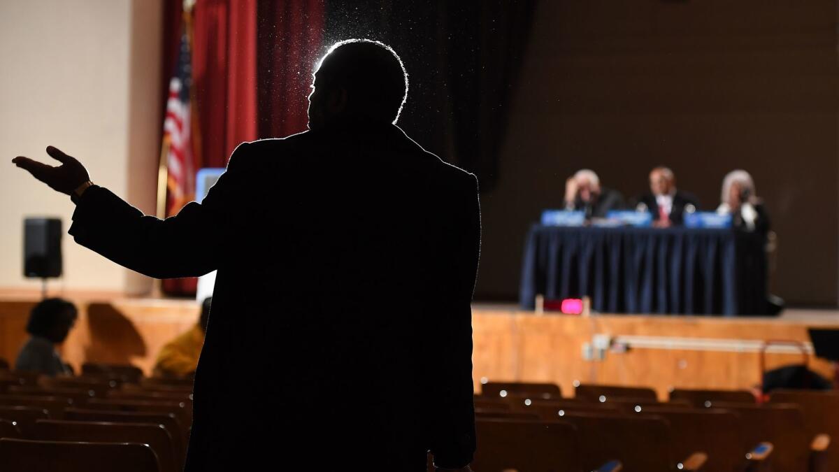 A man talks to L.A. police commissioners at a Feb. 20 meeting in Watts during a citywide listening tour by the civilian board that oversees the LAPD.