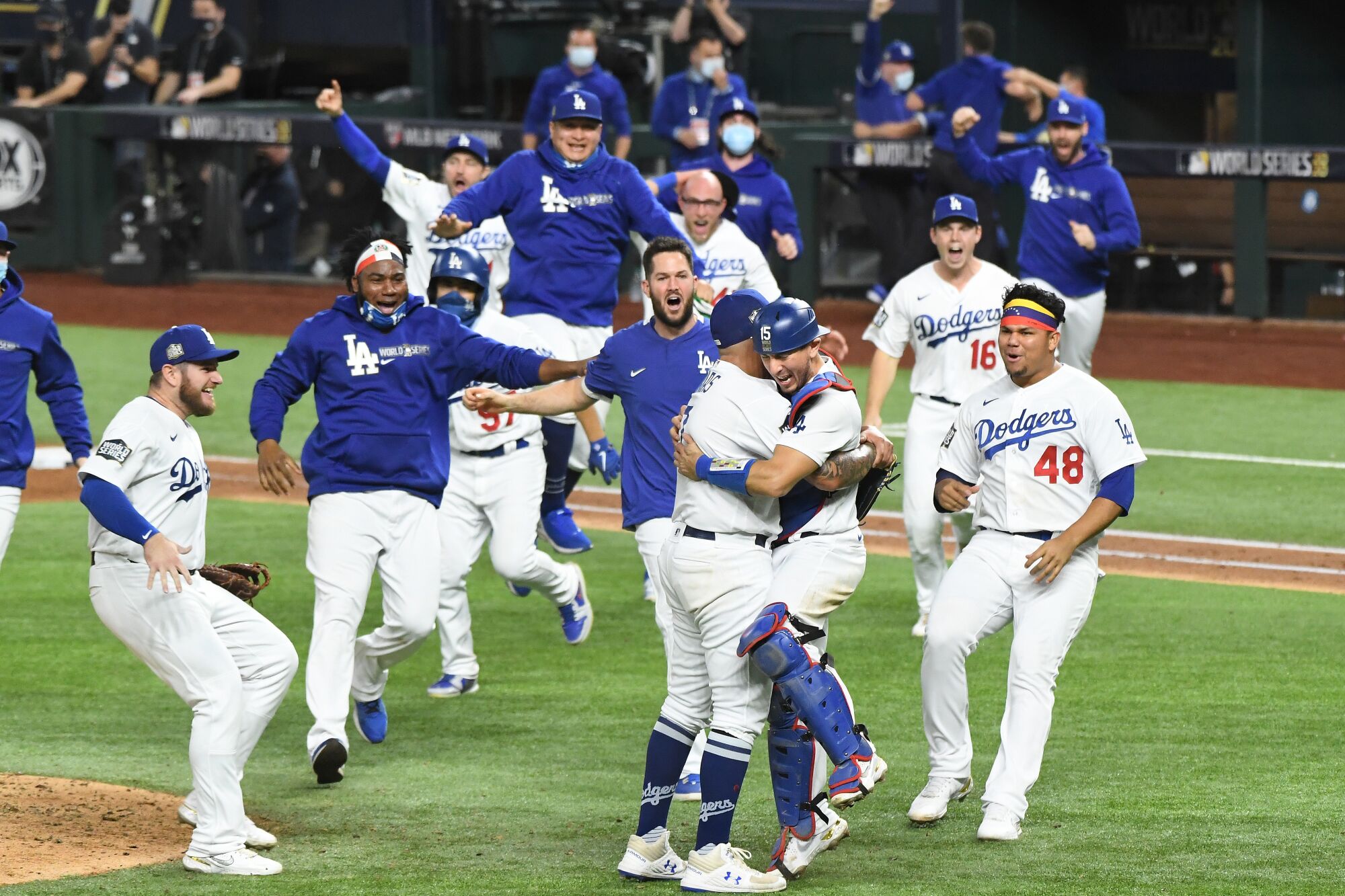Dodgers embrace on the field as they celebrate their World Series win.