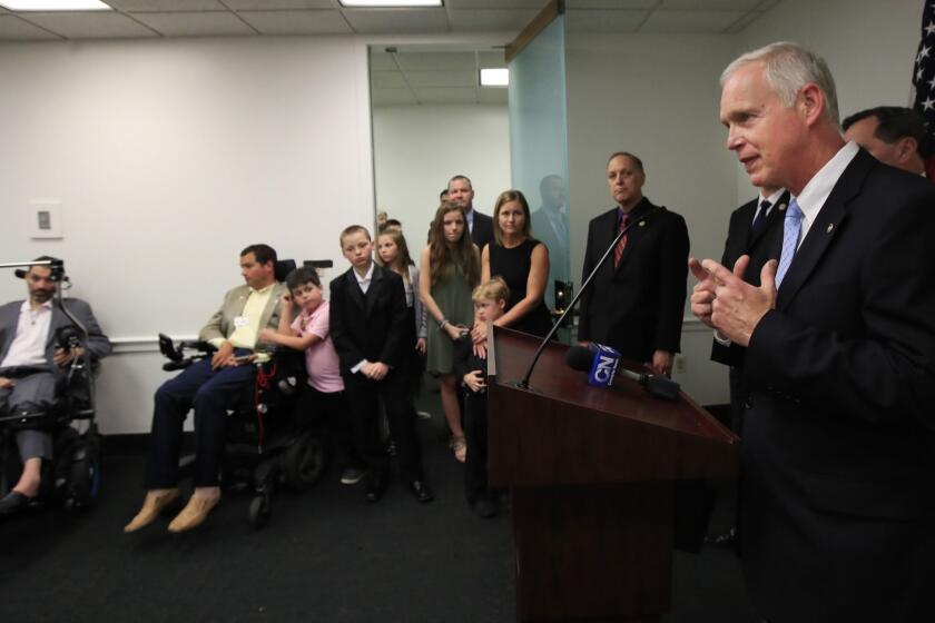 Sen. Ron Johnson, R-Wis., with ALS sufferers Frank Mongiello, from left, and Matthew Bellina, speaks during a news conference following the passage of the Right to Try Act at the Capitol in Washington, Tuesday, May 22, 2018. (AP Photo/Manuel Balce Ceneta)