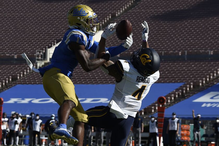 UCLA defensive back Jay Shaw, left, deflects a pass intended for California wide receiver Nikko Remigio.