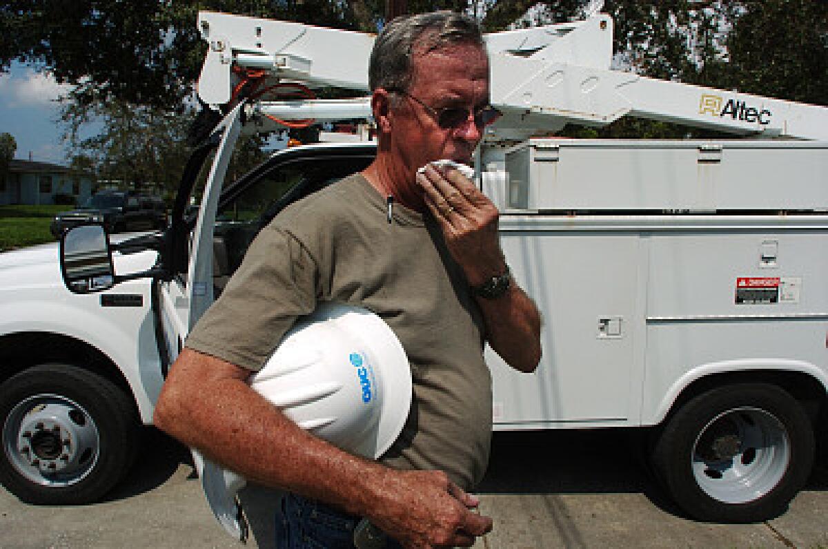 Jim Grantham, 61, a retired Orlando Utilities Commission manager who lives in Georgia, pauses Wednesday while working on power restoration in west Orlando.