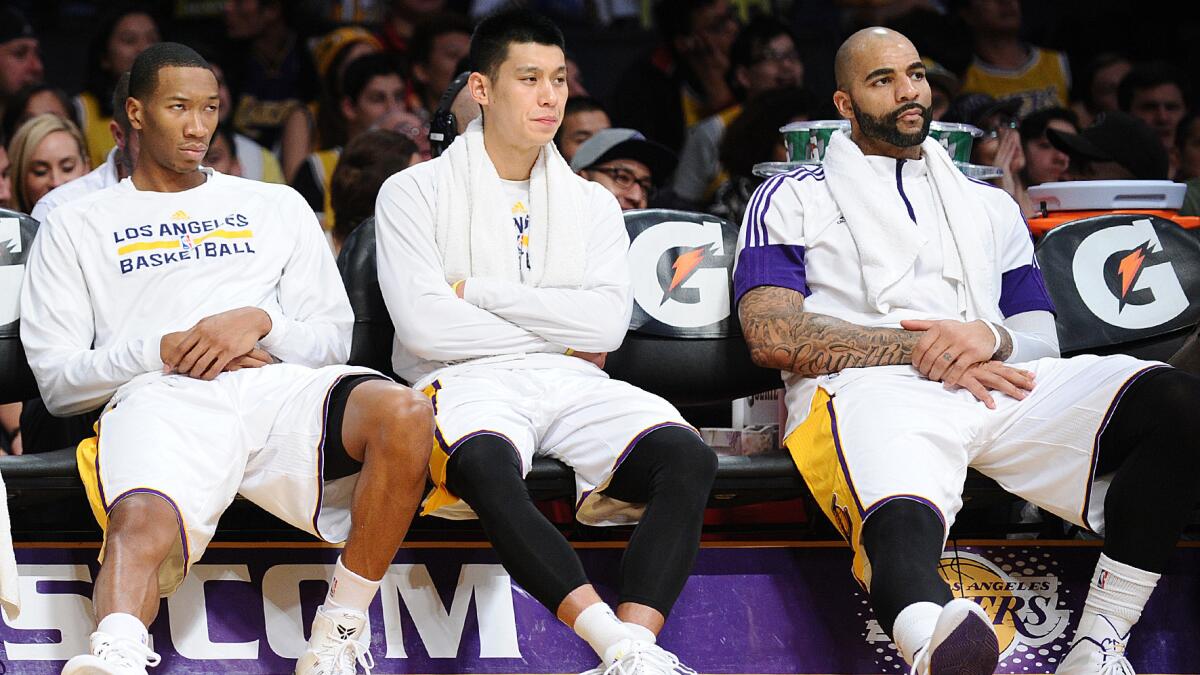 Lakers teammates (from left) Wesley Johnson, Jeremy Lin and Carlos Boozer sit on the bench during a blowout loss to the Golden State Warriors in November.