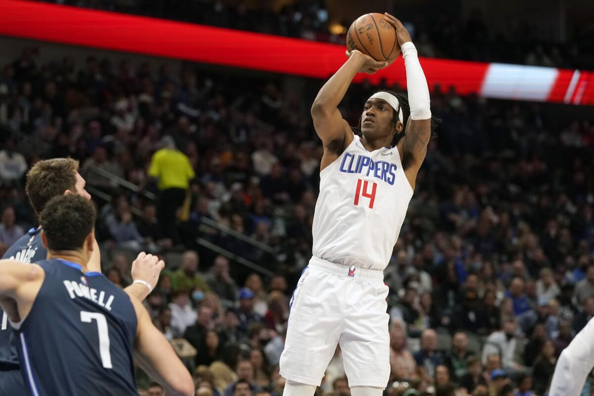 The Clippers' Terance Mann shoots against Dallas defenders Dwight Powell (7) and Luka Doncic.