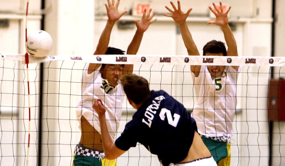 Loyola's Matt Reilly (2) gets a spike past Mira Costa's Trevor Liu and Chris Caskey (5) at Gersten Pavilion on Friday night.