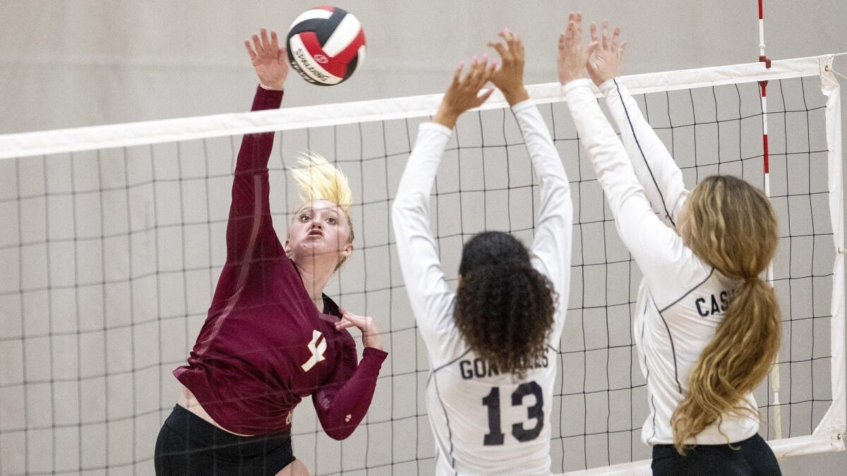 Ocean View High's Katelyn Taylor hits into Chatsworth's blockers Rylee Gonzales, center, and Kelli Cashman in the first round of the CIF State Southern California Regional Division IV playoffs on Tuesday.