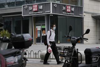 A man wearing a mask walks past the Heaven Supermarket club linked to a recent outbreak of COVID cases, Monday, June 13, 2022, in Beijing. China's capital has put school online in one of its major districts amid the new COVID-19 outbreak linked to the nightclub, while life has yet to return to normal in Shanghai despite the lifting of a more than two-month-long lockdown. (AP Photo/Ng Han Guan)