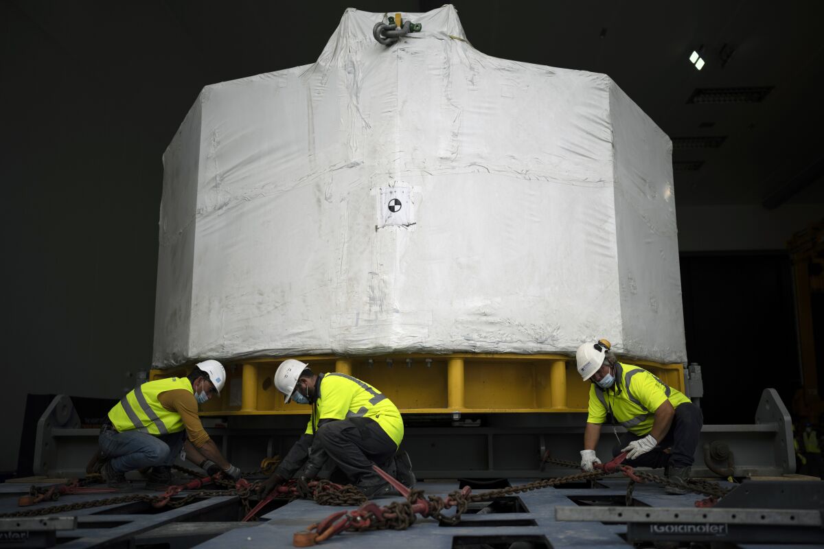 Workers receive a central solinoid magnet for the ITER project in Saint-Paul-Lez-Durance, France, Thursday, Sept. 9, 2021. Scientists at the International Thermonuclear Experimental Reactor in southern France took delivery of the first part of a massive magnet so strong its American manufacturer claims it can lift an aircraft carrier. (AP Photo/Daniel Cole)
