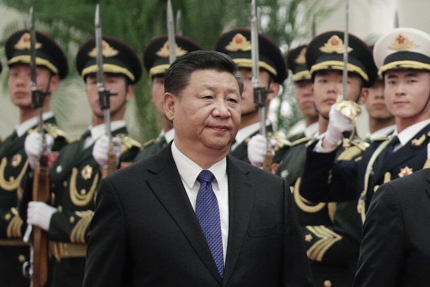 شی جین پینگ رئیس جمهور چین از کنار صفی از سربازان عبور می کند.