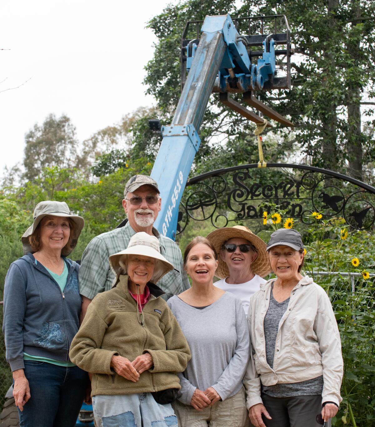 Members of the Huntington Beach Tree Society pose for a photo Friday at the entrance to the Secret Garden.