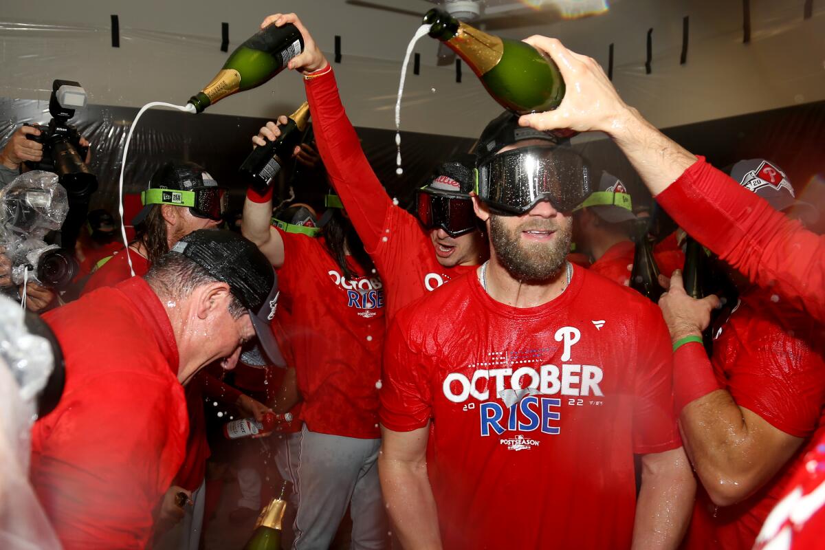 The Phillies' Bryce Harper, front right, celebrates in the clubhouse after a win over the Cardinals on Oct. 8, 2022.