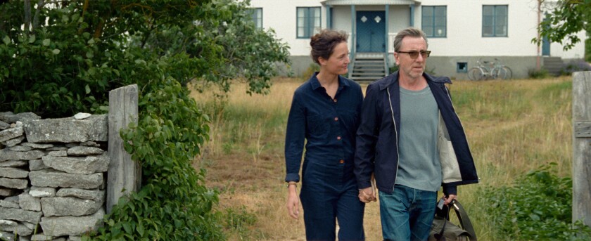 A couple walk hand in hand in the movie “Bergman Island.”