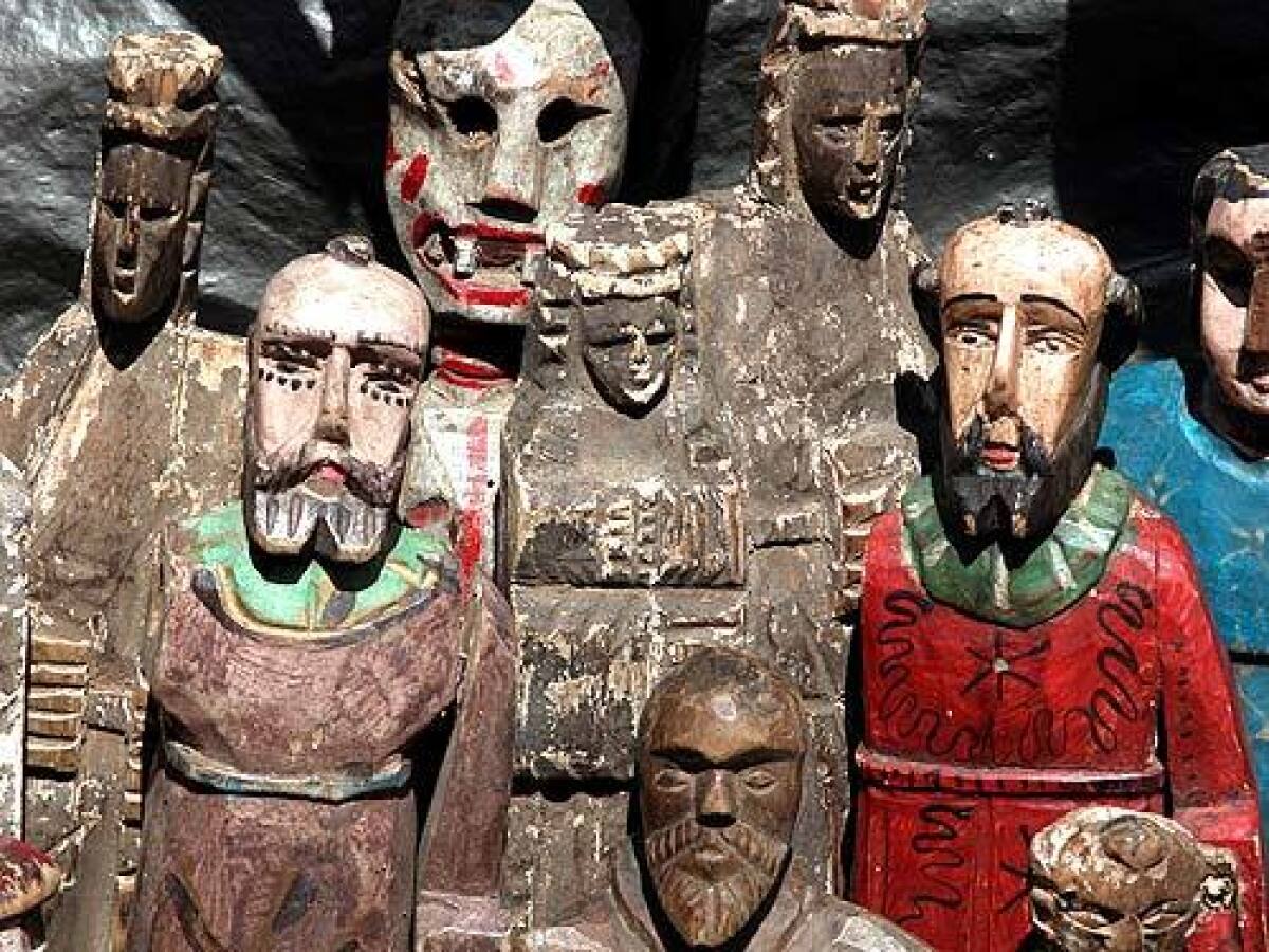 Carved saints at a booth in Chichicastenango, Guatamala.