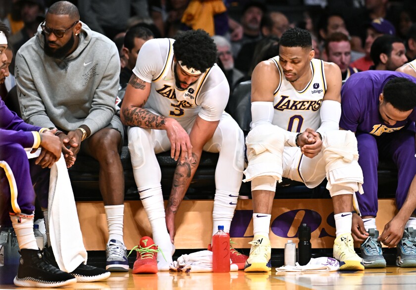 Lakers stars (from left) LeBron James, Anthony Davis and Russell Westbrook watch a game together from the bench.