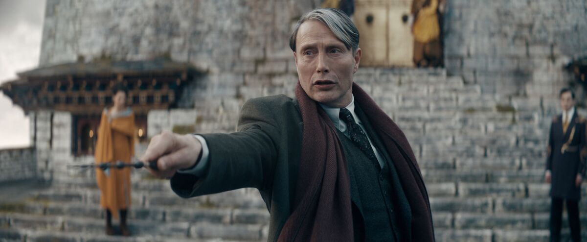 A man in a scarf points a wand in the movie “Fantastic Beasts: The Secrets of Dumbledore”