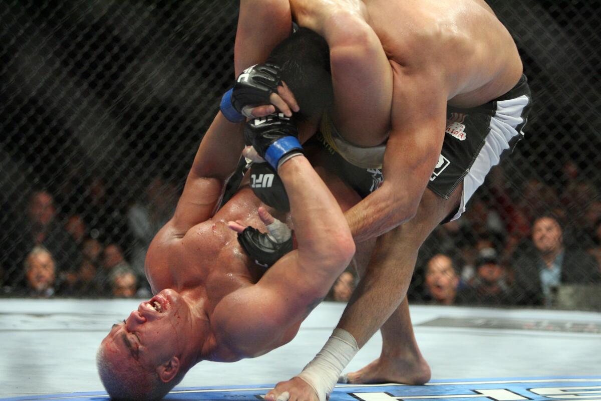 ** FILE ** In this May 24, 2008, file photo, Tito Ortiz, bottom, attempts a triangle choke on Lyoto Machida during their Ultimate Fighting Championship Light Heavyweight match at the MGM Grand Garden Arena in Las Vegas. UFC has come to Washington to engage in the city's ultimate fighting sport: lobbying. The biggest name in mixed martial arts, UFC is a multimillion-dollar business that fills arenas, broadcasts events on pay-per-view and has deals with cable networks like Spike TV. The sport's owners are concerned that it could come under federal regulation by a proposed new commission to regulate boxing that is being pushed by two senior lawmakers.(AP Photo/Eric Jamison)