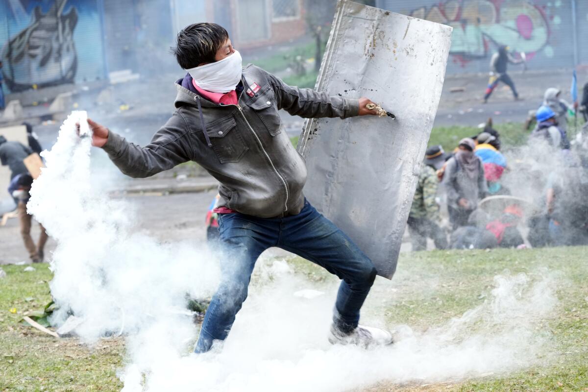 Un manifestante devuelve un bote de gas lacrimógeno durante los enfrentamientos con la policía 