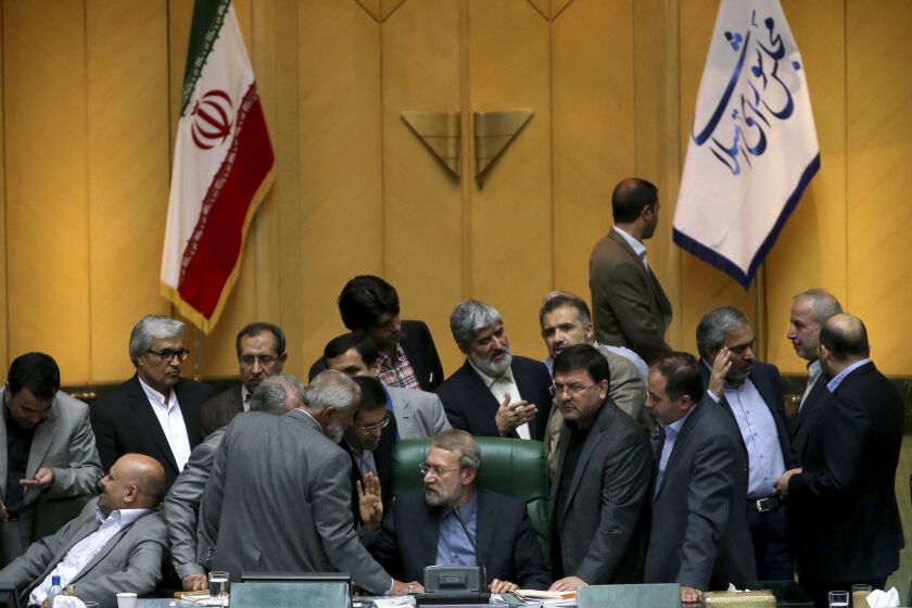 In this photo taken Sunday, Iran's parliament speaker Ali Larijani, center, speaks with lawmakers in an open session of parliament while discussing a bill on Iran's nuclear deal with world powers, in Tehran.