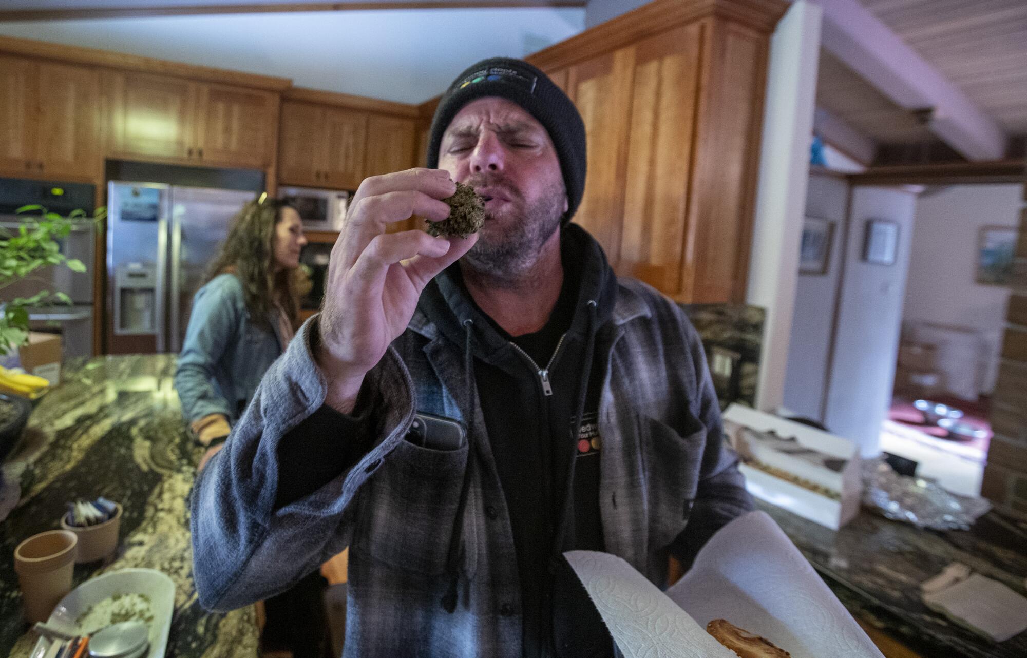 A man inspects a cannabis nug.