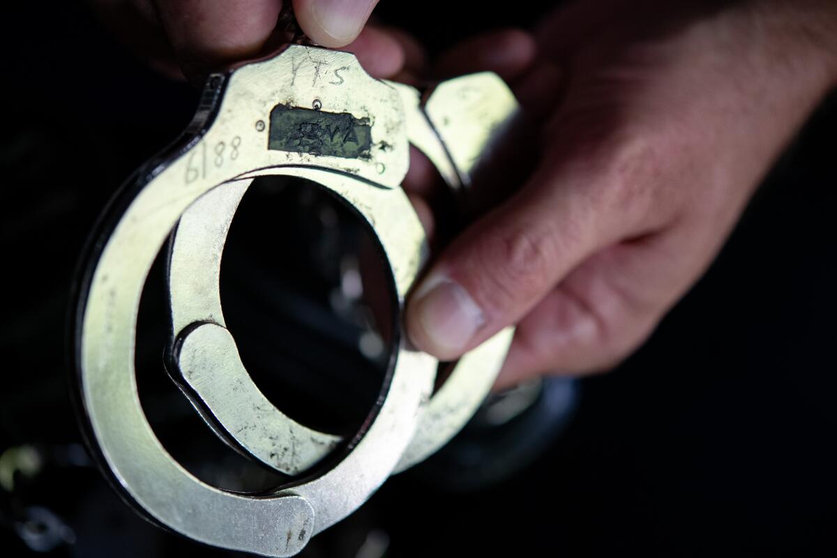 David Reeve holds a set of handcuffs given to him by a former guard at Youth Training School.