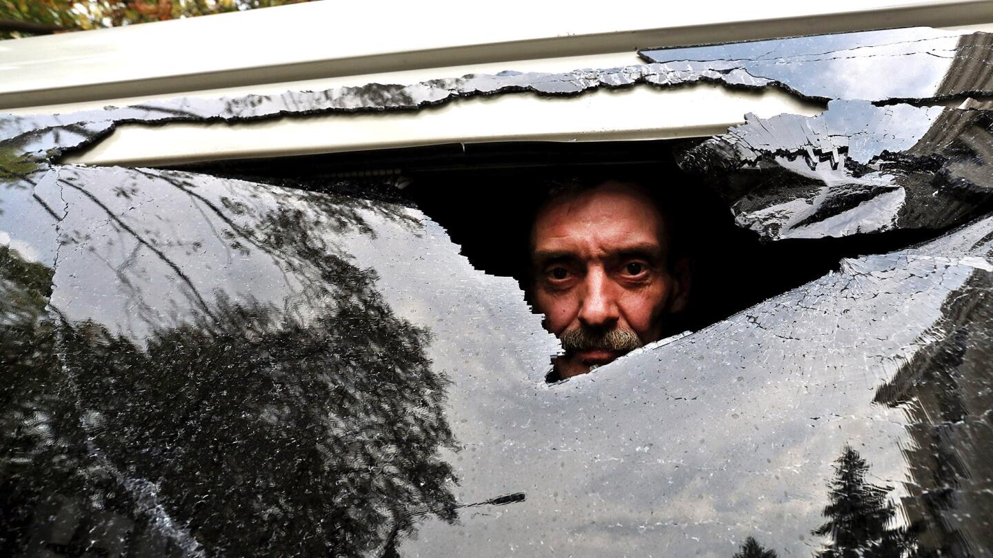 Hired driver Alexander Kosenko looks through a broken window of his minibus, hit by shrapnel during fighting between Ukrainian government troops and pro-Russia separatists in Donetsk.