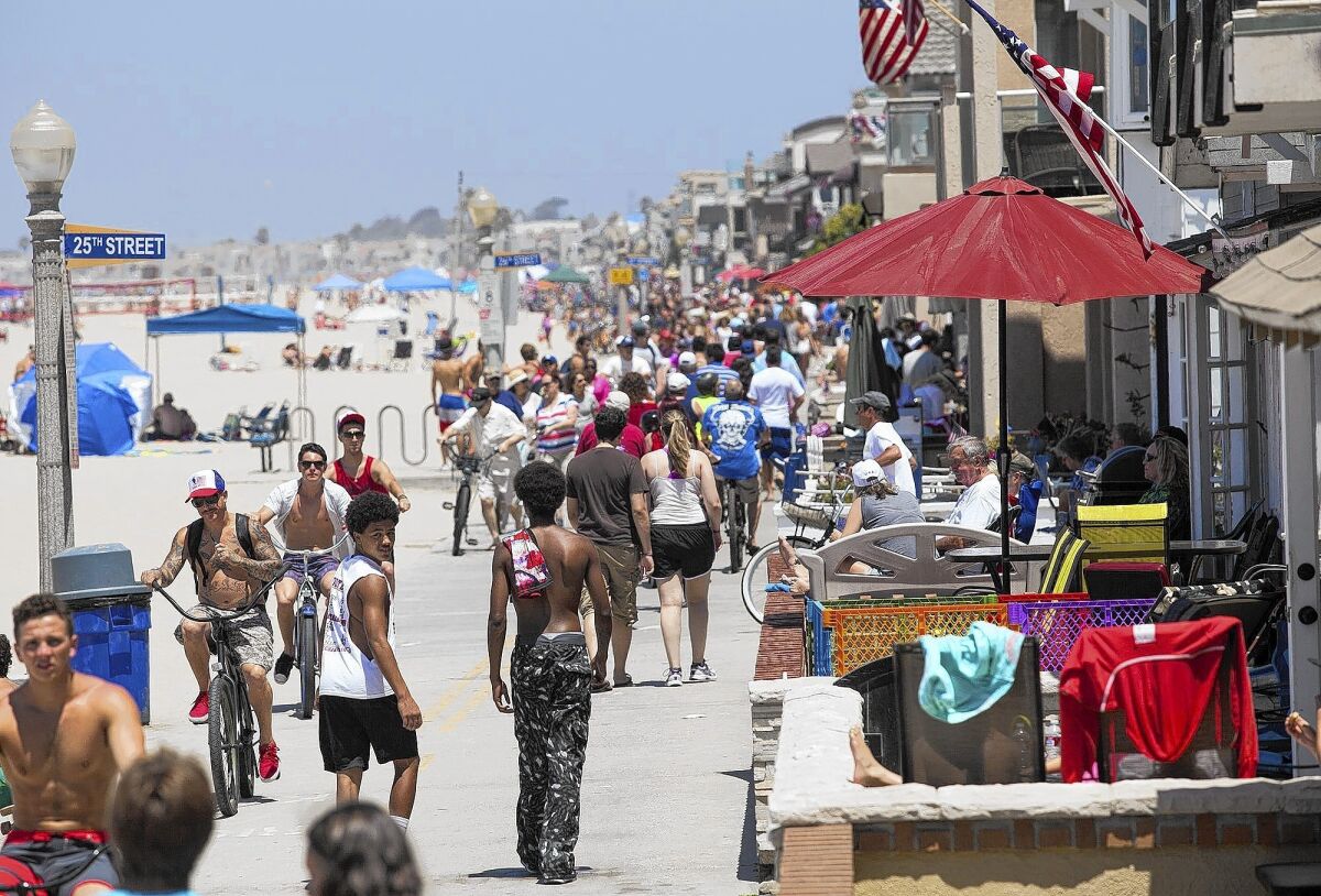 Hundreds of people visit the Balboa Peninsula boardwalk in Newport Beach on the Fourth of July in 2014.