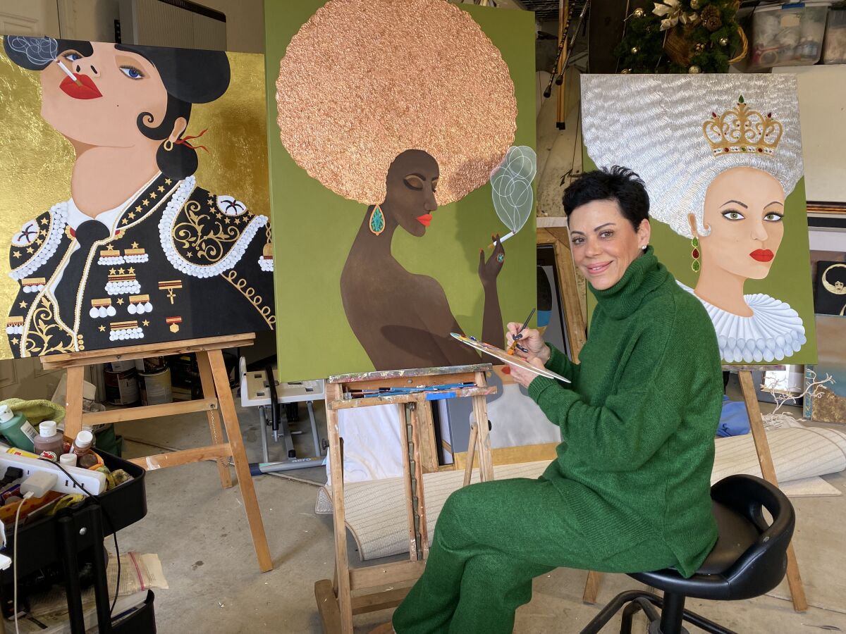 Artist Czarina Scolari, who is one of the artists featured at Mission Fed ArtWalk Little Italy, poses with her paintings.