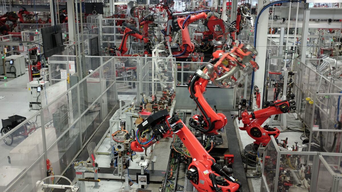 Machines work inside Tesla's automobile assembly plant in Fremont, Calif.