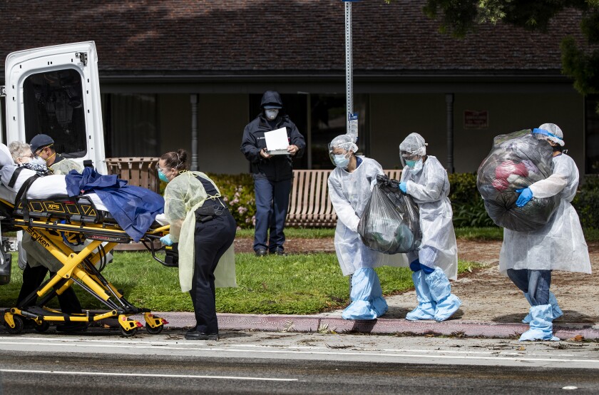 Medical staff carry a patient's belongings as she is evacuated from Magnolia Rehabilitation and Nursing Center last month.