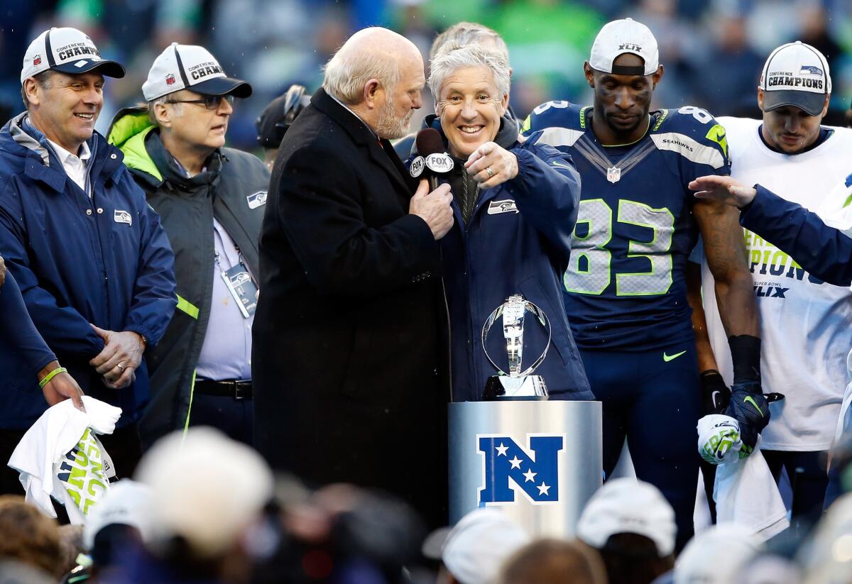 Fox broadcaster Terry Bradshaw, third from left, interviews Seattle Coach Pete Carroll after the NFC championship game.