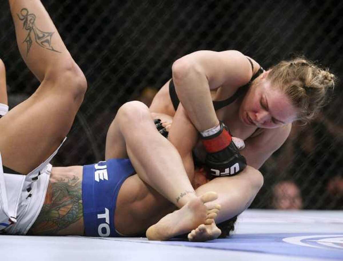 Ronda Rousey, top, got Liz Carmouche to submit with an armbar in the first round of the UFC 157 Saturday at the Honda Center in Anaheim.