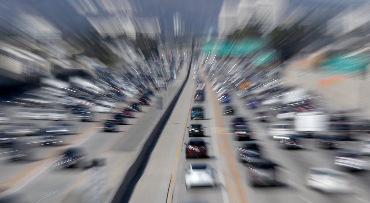 A blurred image of cars on a crowded freeway.