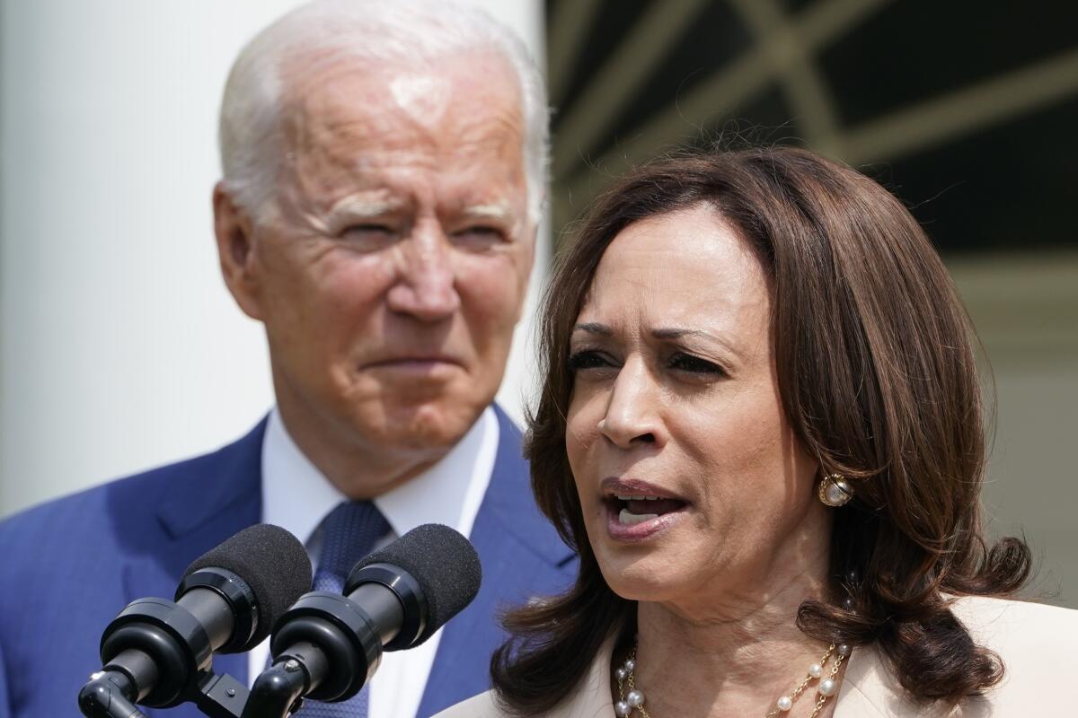 President Joe Biden, left, listens to Vice President Kamala Harris, right, speak at an event in the White House Rose Garden.