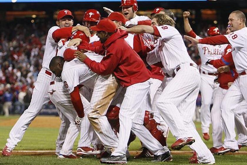Phillies teammates mob Jimmy Rollins after he hit a two-run double off Dodgers closer Jonathan Broxton with two outs in the bottom of the ninth inning to give Philadelphia a 5-4 victory over the Dodgers in Game 4 of the NLCS.