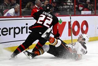 Anaheim Ducks center Sam Carrick (39) falls after clashing with Ottawa Senators defenseman Nikita Zaitsev (22) during first-period NHL hockey game action in Ottawa, Ontario, Monday, Dec. 12, 2022. (Justin Tang/The Canadian Press via AP)