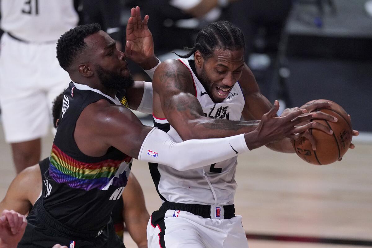 The Clippers' Kawhi Leonard comes down with the ball against the Denver Nuggets' Paul Millsap.