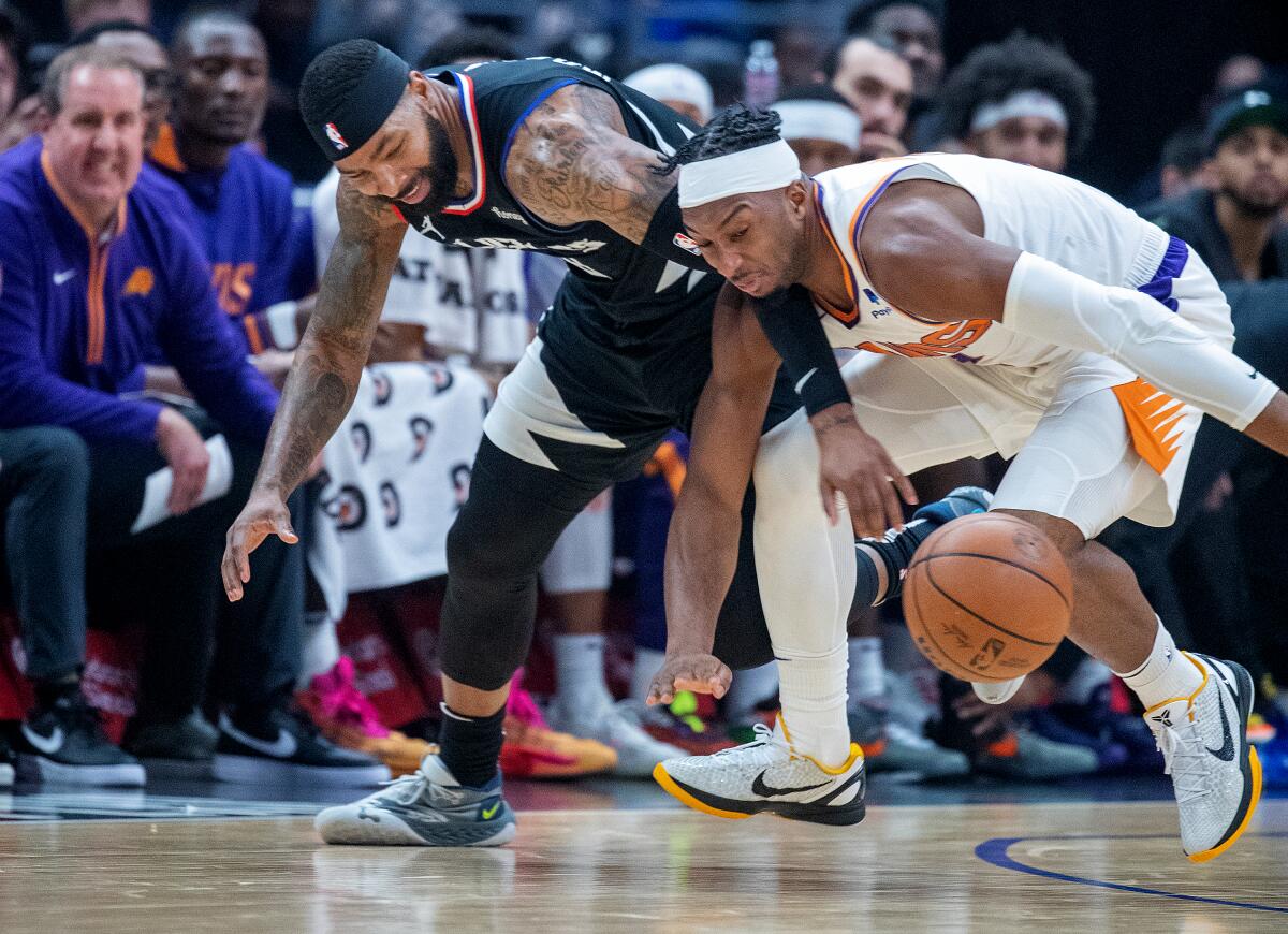 Clippers forward Marcus Morris Sr. battles Suns guard Josh Okogie for a loose ball.