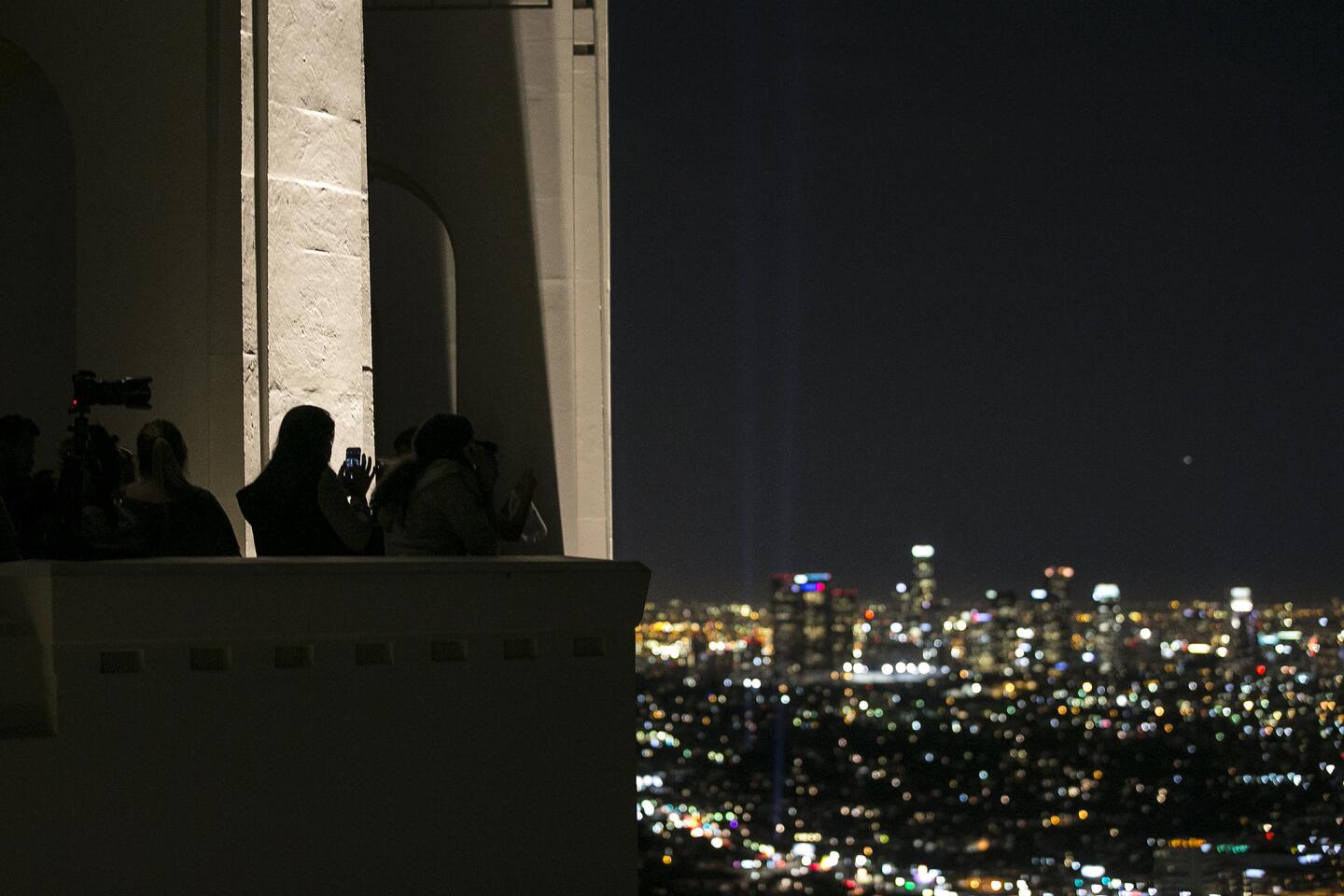 Spectators and photographers line up on March 13, at the Griffith Park Observatory to view spotlights lighting the route of the L.A. Marathon from Dodger Stadium to Santa Monica.