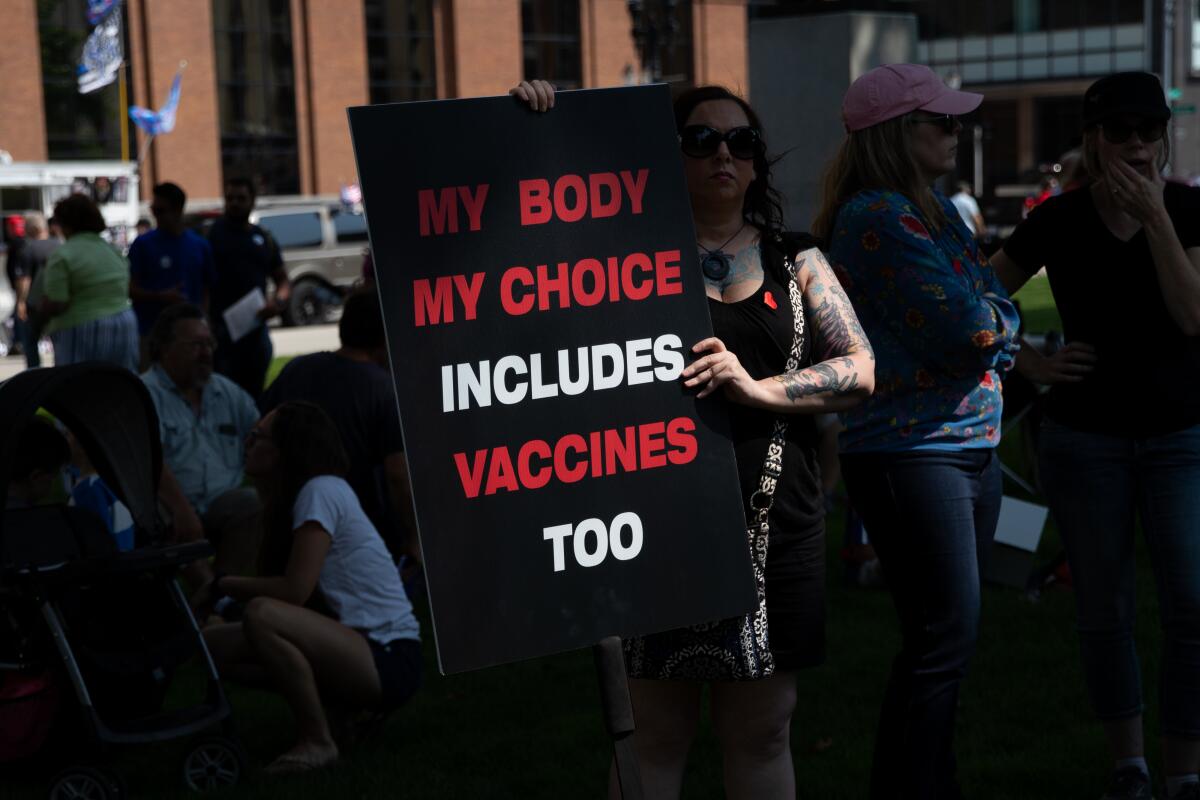 People opposed to COVID-19 vaccine mandates protest outside the Michigan Capitol.