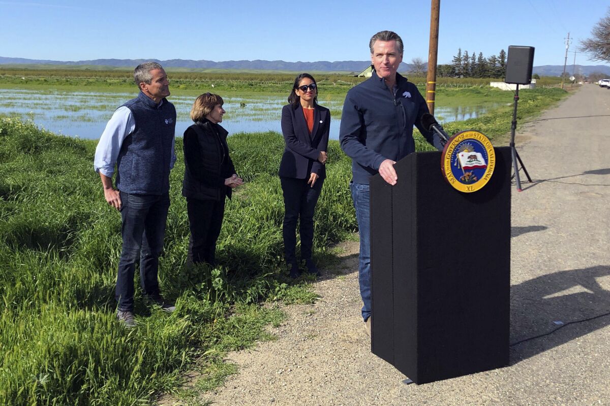 California Gov. Gavin Newsom talks during a news conference from a farm in Dunnigan, Calif., Friday, March 24, 2023. Newsom announced an end to some drought restrictions and calls for water conservation, following a series of winter storms have dramatically improved the state's water supply outlook. (AP Photo/Adam Beam)