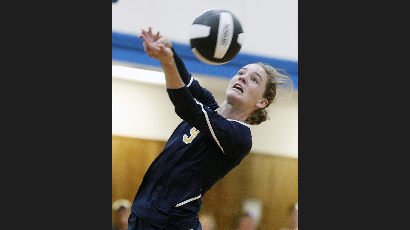 St. Monica Academy's Katherine Golbranson gets outside the court to save the ball and hit it back to International School of Los Angeles in an International League girls' volleyball match at the Olive Park Recreation Center in Burbank on Wednesday, September 27, 2017.