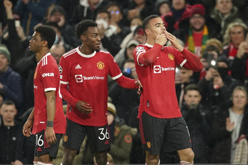 Manchester United's Mason Greenwood, right, celebrates after scoring the opening goal during the Champions League group F soccer match between Manchester United and Young Boys, at Old Trafford stadium in Manchester, England, Wednesday, Dec. 8, 2021. (AP Photo/Dave Thompson)