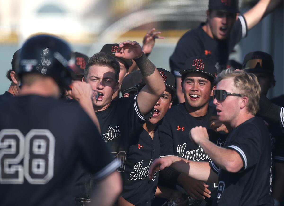 The Huntington Beach bench erupts in cheers during Tuesday's Surf League game against Edison.