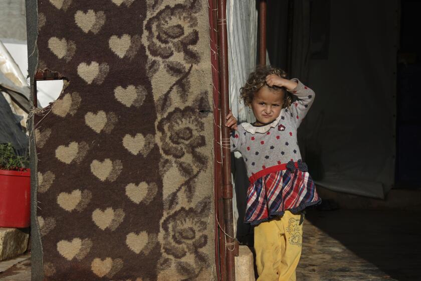 Una niña siria desplazada en un campamento en el noroeste de Siria está parada afuera de una tienda de campaña en la aldea de Harbnoush, el lunes 13 de mayo de 2024. (AP Photo/Omar Albam)