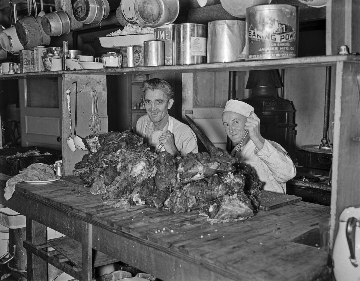 Nov. 26, 1936: Bob Boyd and Chef George Arnold in a kitchen cutting beef for Thanksgiving dinner at the Union Rescue Mission.